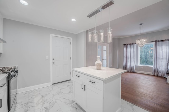 kitchen featuring white cabinetry, a kitchen island, hanging light fixtures, and stainless steel gas range