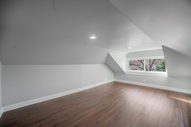 bonus room with dark hardwood / wood-style flooring and vaulted ceiling