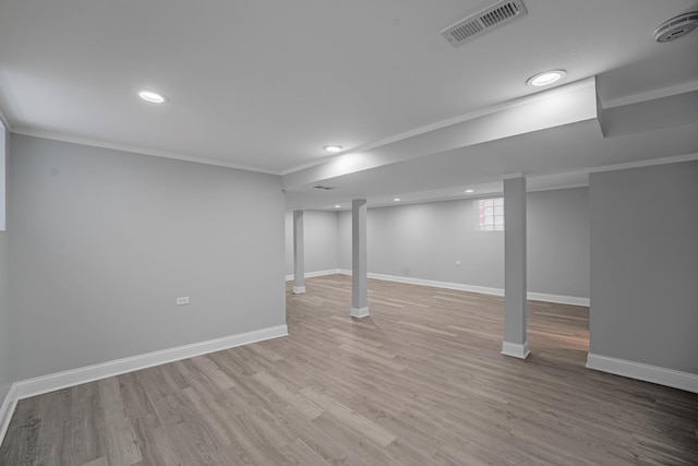 basement with light wood-type flooring and ornamental molding