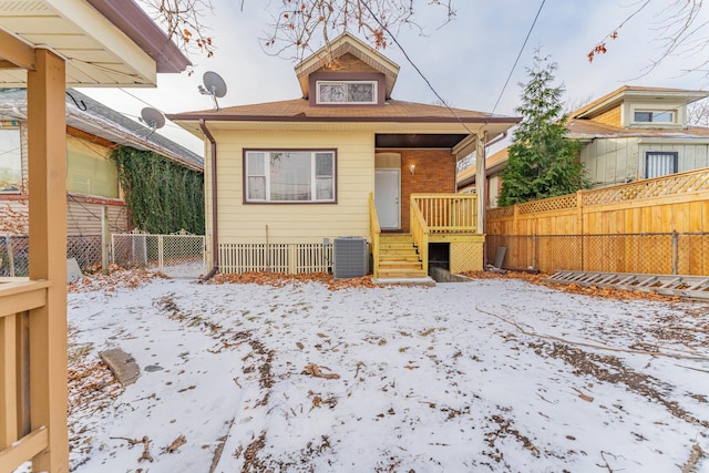 snow covered property with central air condition unit