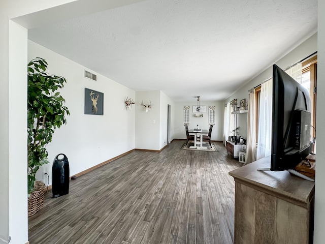 interior space featuring a textured ceiling, plenty of natural light, and dark wood-type flooring