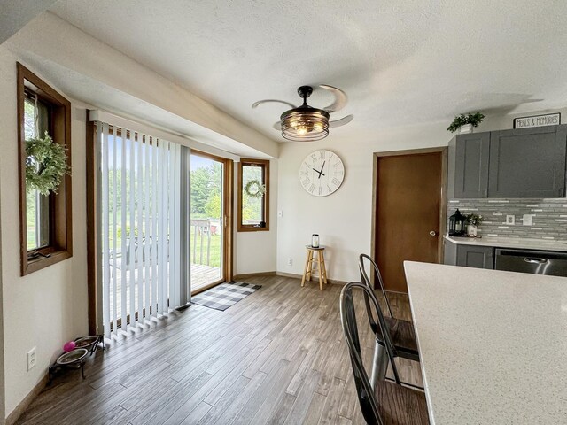 dining room featuring ceiling fan, a textured ceiling, and light hardwood / wood-style flooring