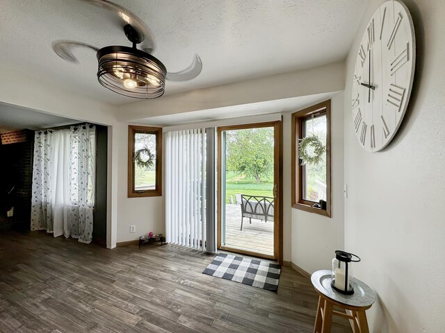 foyer with ceiling fan, dark hardwood / wood-style flooring, and a textured ceiling