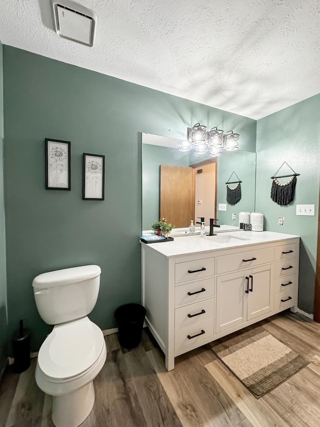 bathroom featuring a textured ceiling, hardwood / wood-style flooring, and toilet