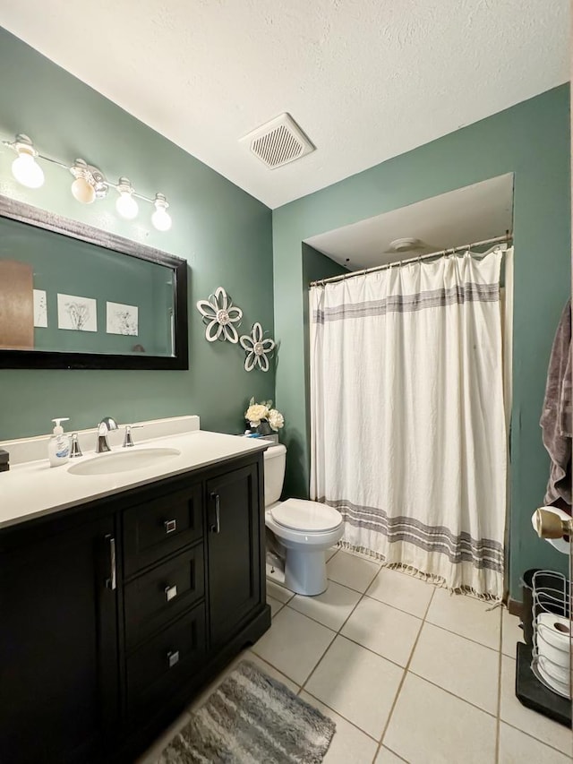 bathroom featuring tile patterned flooring, a textured ceiling, vanity, and toilet