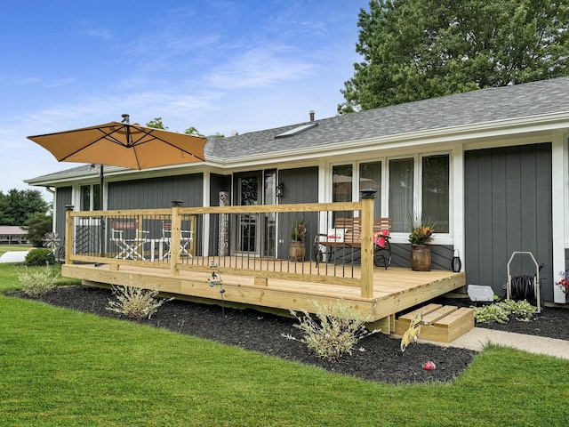 back of house featuring a lawn and a deck