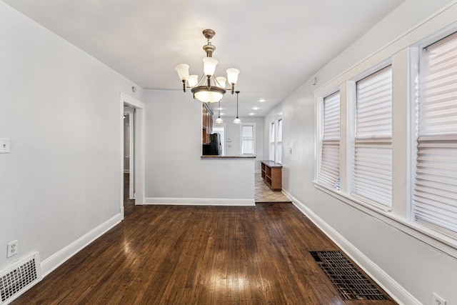 interior space featuring a chandelier and dark hardwood / wood-style floors