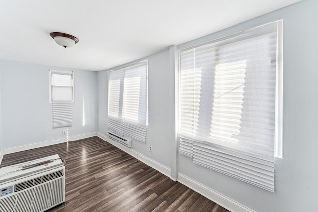 empty room featuring dark hardwood / wood-style flooring and a wall unit AC