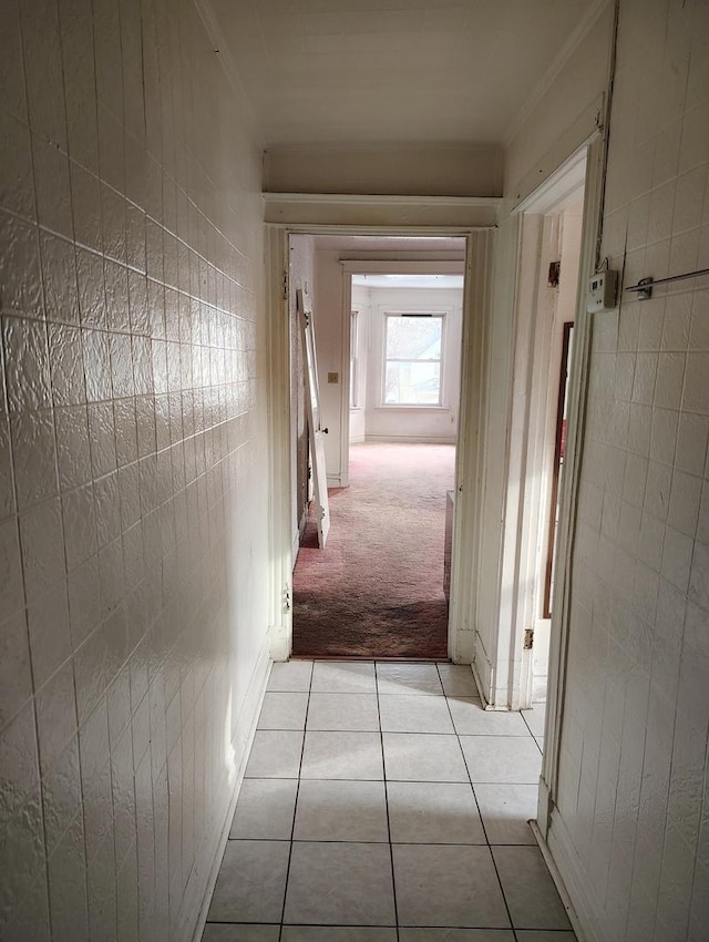 corridor with light tile patterned floors and ornamental molding