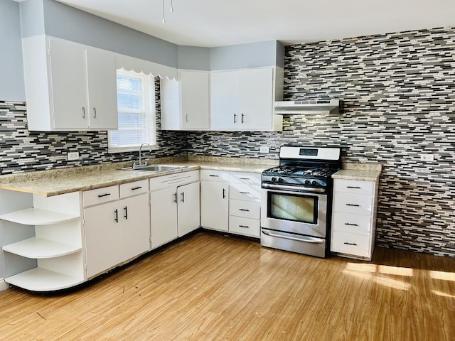 kitchen with white cabinets, exhaust hood, sink, and stainless steel gas range