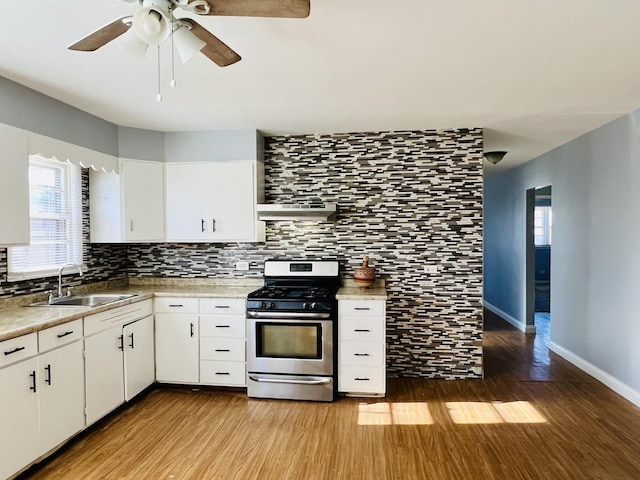 kitchen with white cabinets, stainless steel gas range oven, and sink