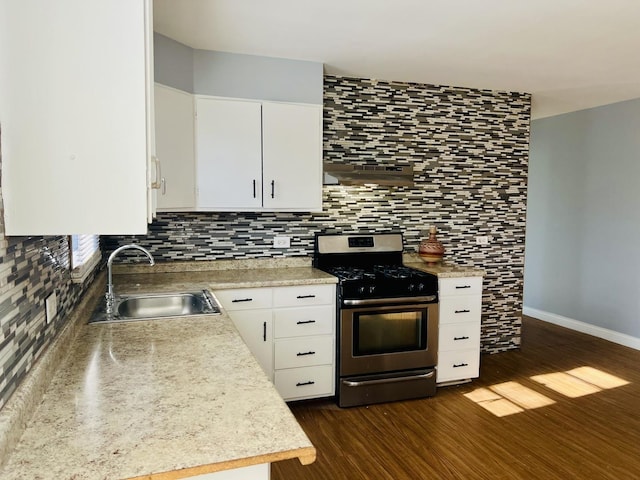 kitchen with sink, stainless steel gas range, dark hardwood / wood-style flooring, extractor fan, and white cabinets