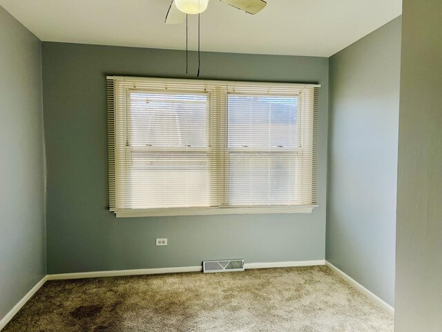 spare room featuring light carpet and ceiling fan