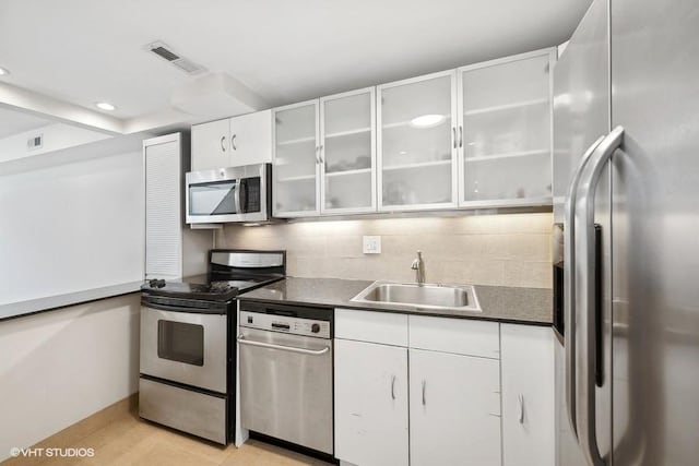 kitchen with light hardwood / wood-style floors, stainless steel appliances, decorative backsplash, white cabinets, and sink