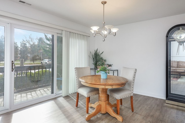 dining room with wood-type flooring and an inviting chandelier