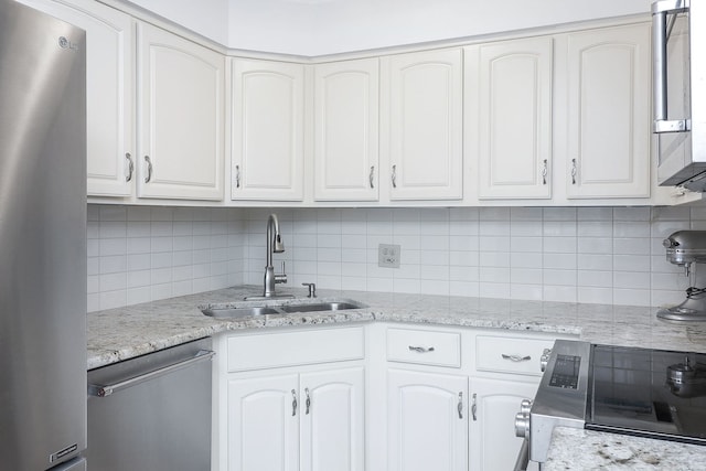 kitchen with backsplash, sink, white cabinets, and appliances with stainless steel finishes