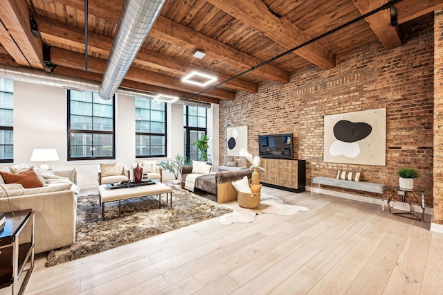 living room with beamed ceiling, light wood-type flooring, brick wall, and wooden ceiling