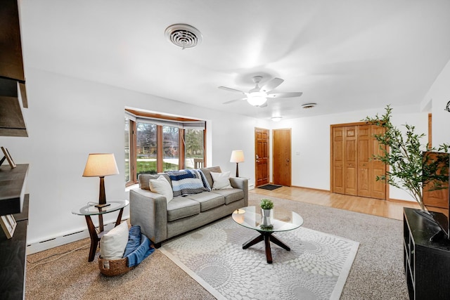 living room featuring ceiling fan, baseboard heating, and light hardwood / wood-style flooring