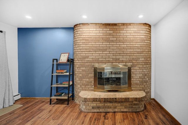 unfurnished living room with hardwood / wood-style floors and baseboard heating