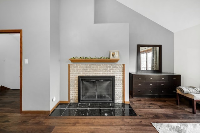 living room featuring a fireplace, vaulted ceiling, and dark wood-type flooring