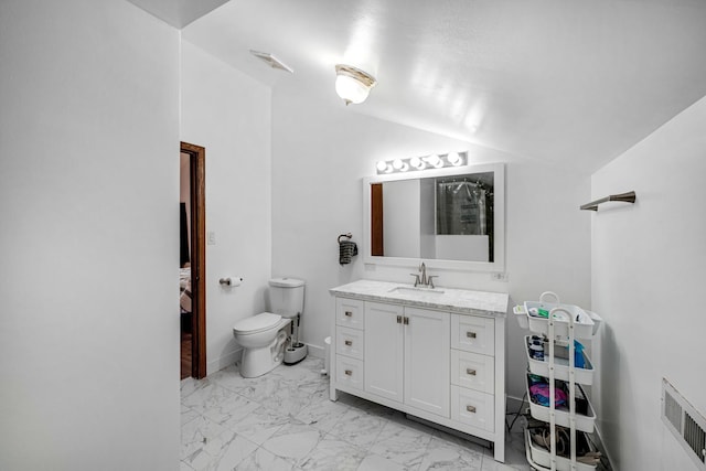 bathroom featuring vanity, toilet, and lofted ceiling