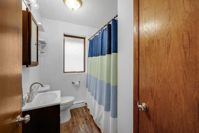 bathroom with vanity, hardwood / wood-style flooring, toilet, and a baseboard heating unit