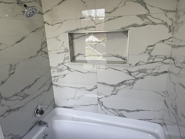 bathroom featuring tiled shower / bath