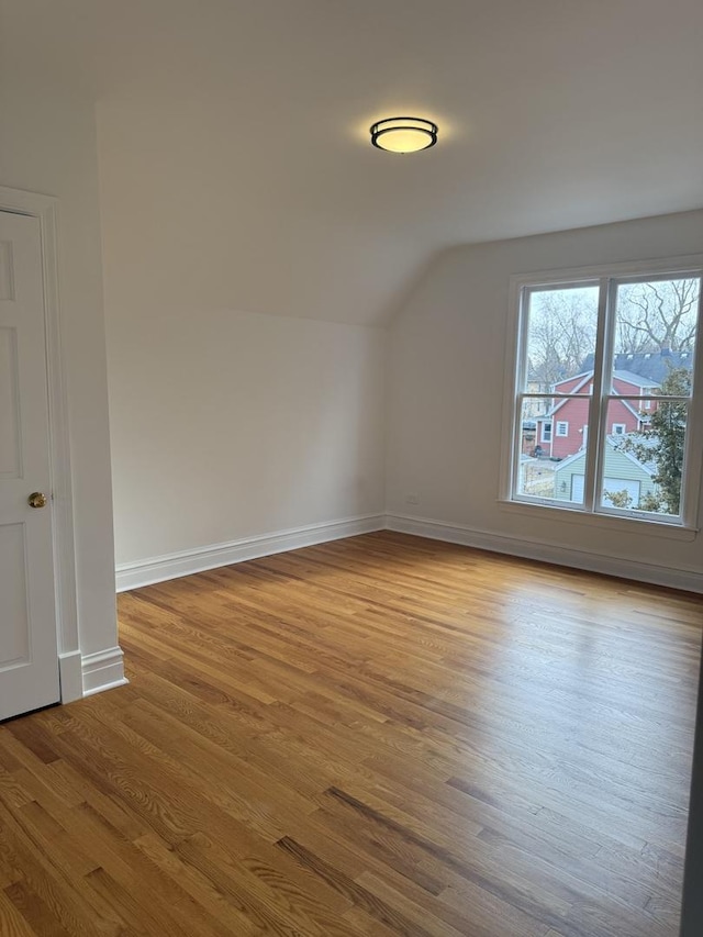 additional living space with lofted ceiling and light wood-type flooring