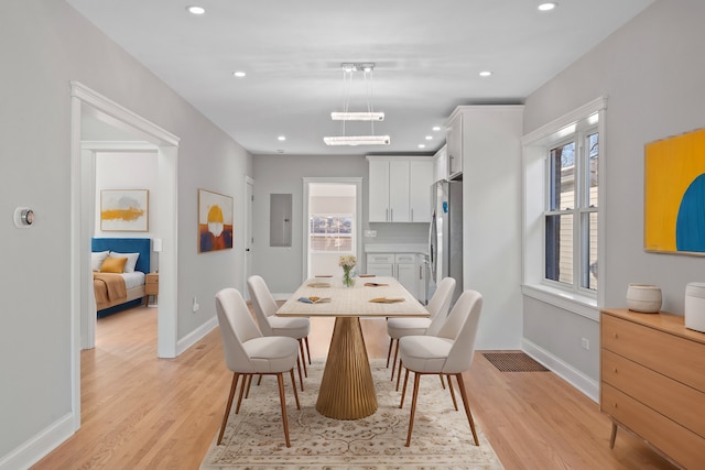 dining area featuring electric panel and light hardwood / wood-style floors