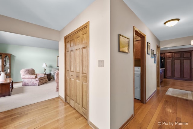 hallway featuring washer / dryer and light hardwood / wood-style floors