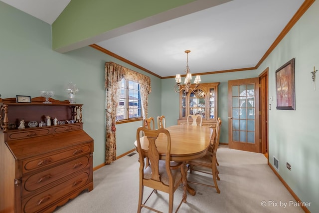 dining room featuring light colored carpet, a chandelier, and ornamental molding