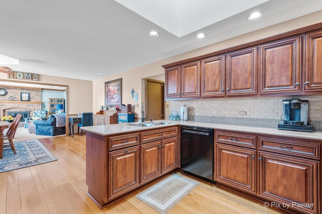 kitchen featuring backsplash, sink, a fireplace, black dishwasher, and kitchen peninsula