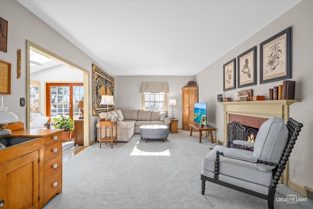 carpeted living room featuring lofted ceiling and a brick fireplace