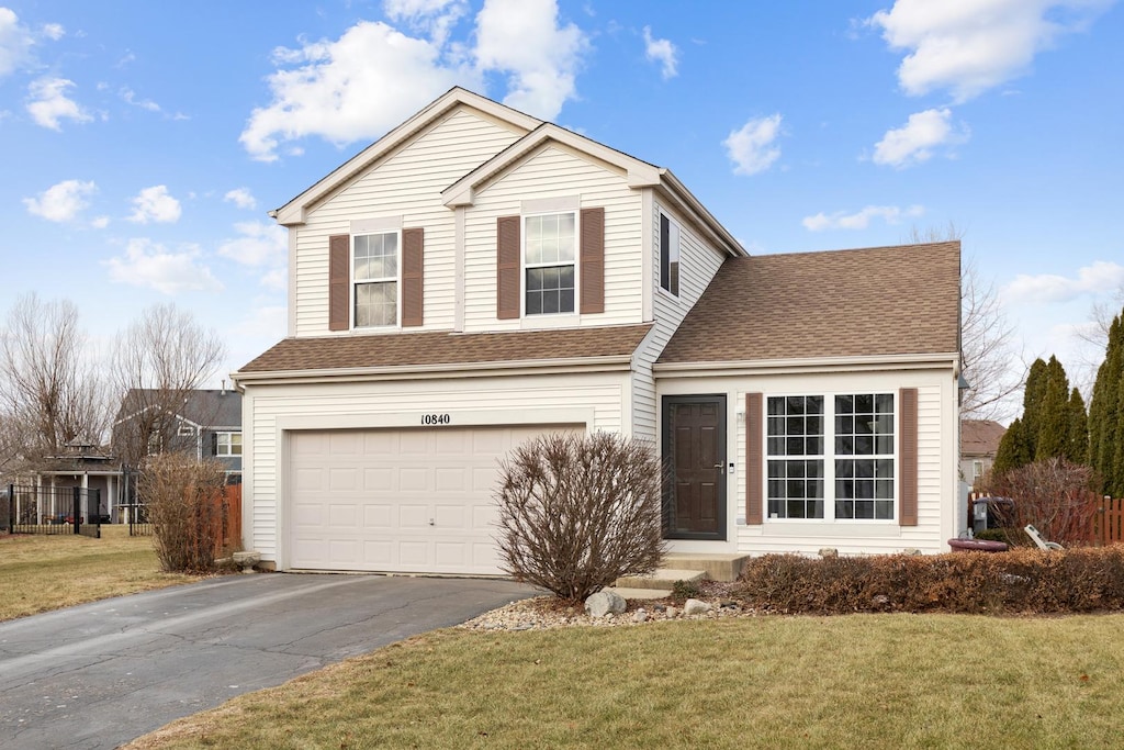 view of front property featuring a garage and a front lawn