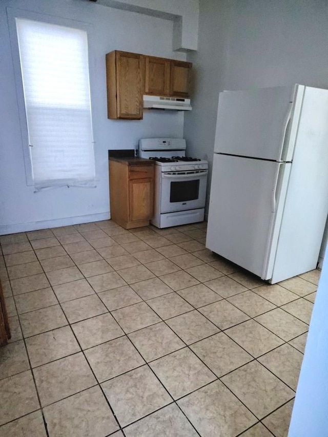 kitchen featuring light tile patterned floors and white appliances