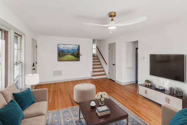 living room featuring hardwood / wood-style floors and ceiling fan