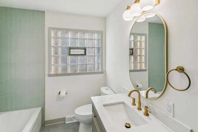 bathroom featuring tile patterned flooring, vanity, toilet, and a tub to relax in