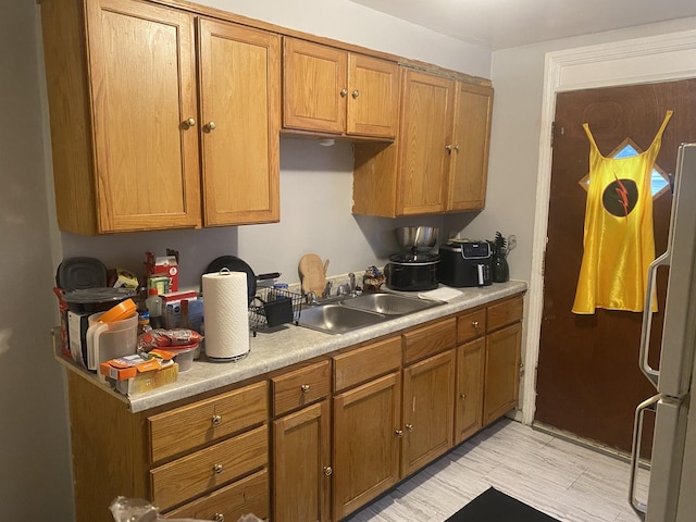 kitchen featuring refrigerator and sink