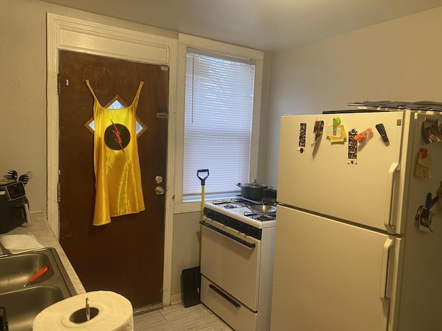 kitchen featuring white appliances and sink