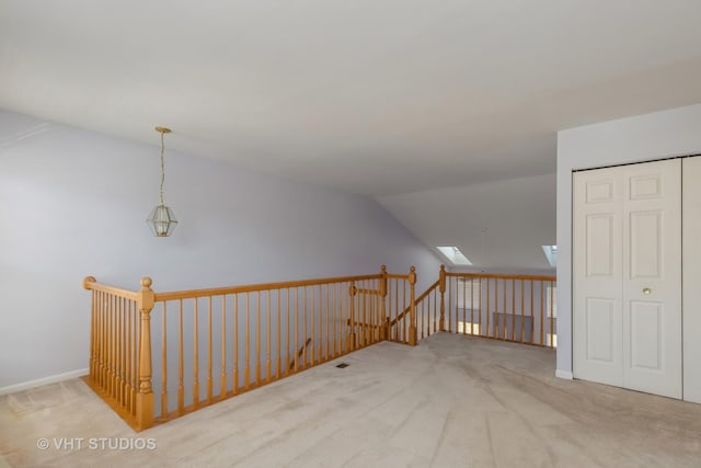 bonus room with lofted ceiling with skylight and light carpet