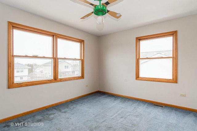 spare room with plenty of natural light, carpet floors, and ceiling fan