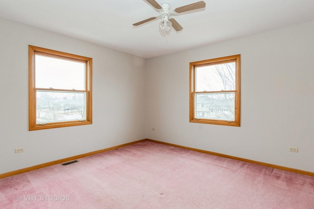 carpeted spare room with ceiling fan