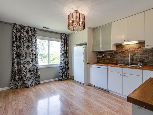 kitchen with white appliances, sink, tasteful backsplash, light hardwood / wood-style floors, and white cabinetry