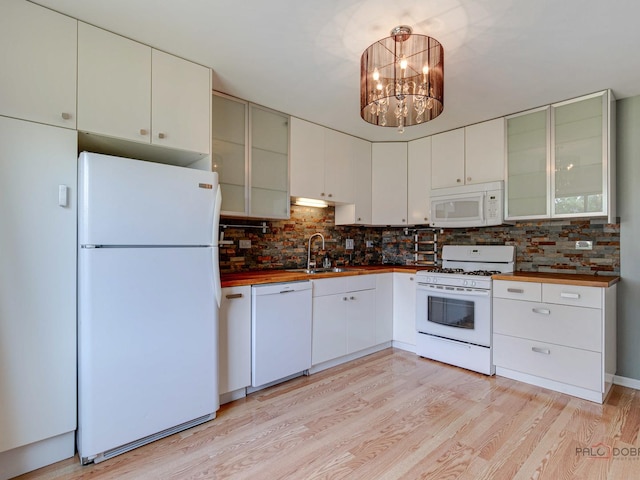 kitchen with white cabinetry, sink, tasteful backsplash, a chandelier, and white appliances