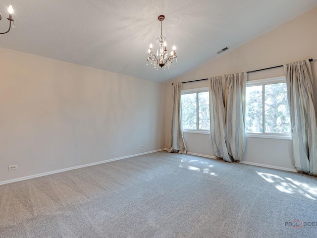 carpeted spare room with lofted ceiling and a chandelier