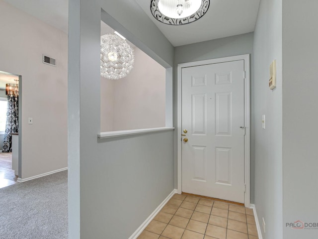 entryway with a chandelier and light tile patterned floors