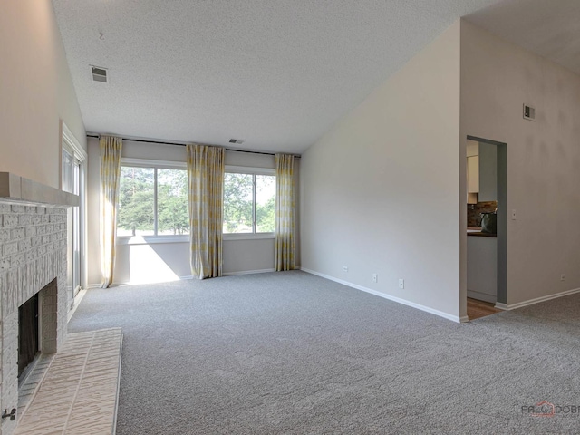 unfurnished living room featuring a fireplace, a textured ceiling, and light colored carpet