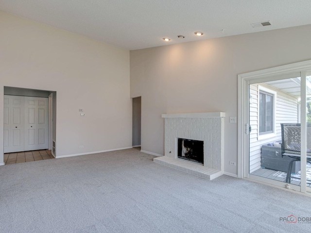 unfurnished living room with light colored carpet, a brick fireplace, and lofted ceiling