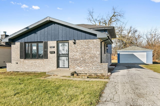 view of front of home featuring a garage, an outdoor structure, and a front lawn