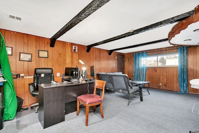 office space featuring light carpet, beam ceiling, and wood walls